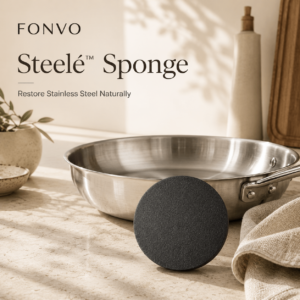 FONVO Steelé Sponge cleaning stainless steel cookware naturally in a luxury European kitchen setting with warm sunlight, soft linens, and premium home aesthetics.